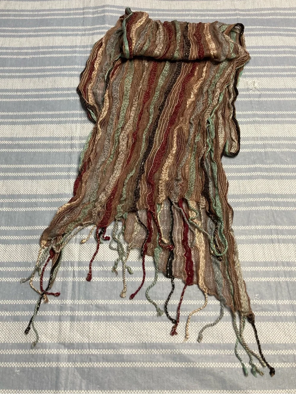 Designer earth toned scarf with fringed bottom.